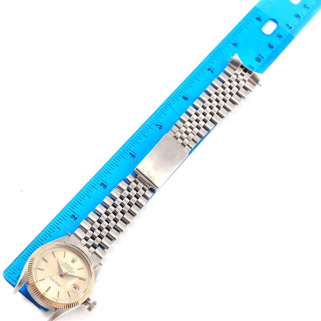 The Rolex Vintage Collection 6605 Men's Stainless Steel Silver Dial 6605 Men's Stainless Steel Silver Dial watch is shown from an overhead angle alongside a blue ruler, highlighting its face and bracelet.