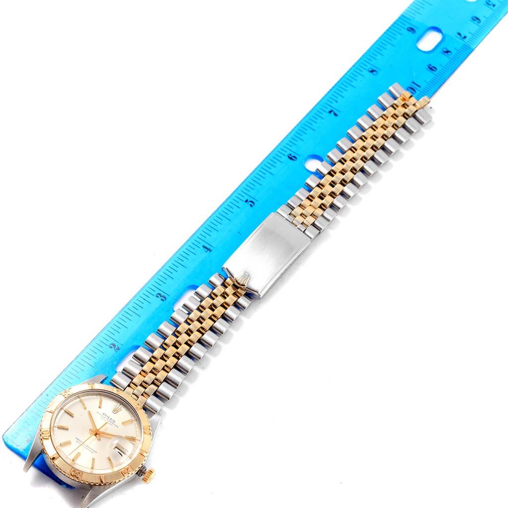 The image shows a Rolex Vintage Collection 1625 Men's Steel and Gold (two tone) Silver Dial 1625 Men's Steel and Gold (two tone) Silver Dial watch at an overhead angle, highlighting the face, band, and a blue ruler for scale.