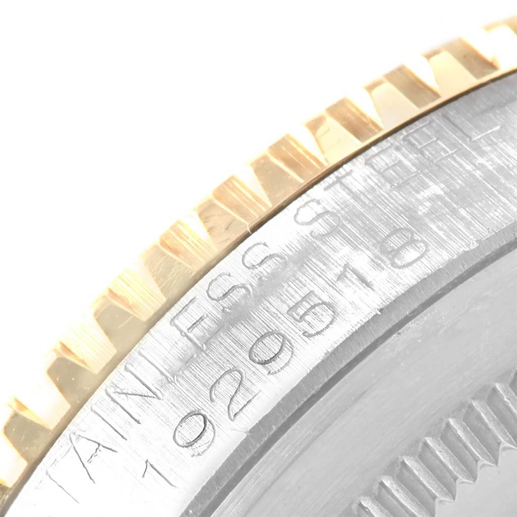 The image shows a close-up angle of the etched serial number and fluted bezel on the Vintage Collection Rolex watch.