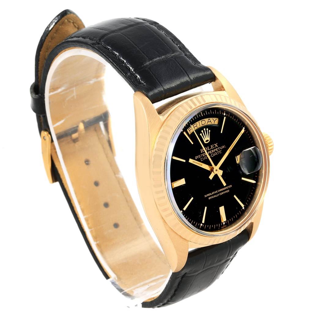 The Vintage Collection model by Rolex is shown at an angle displaying the black dial, gold case, day-date feature, and leather strap.