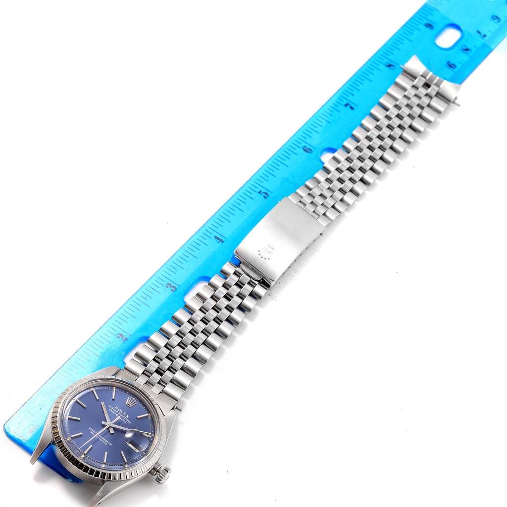 The Vintage Collection Rolex watch is shown from an overhead angle, displaying the face, bezel, bracelet, and a clasp on a ruler.