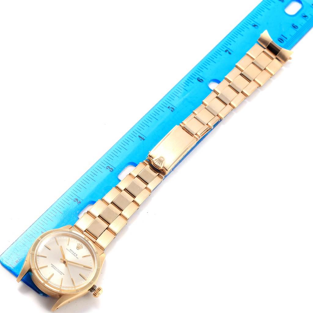 The image shows a Rolex Vintage Collection 1007 Men's Yellow Gold Silver Dial 1007 Men's Yellow Gold Silver Dial watch laid flat next to a ruler, displaying the entire band and face from a top-down angle.