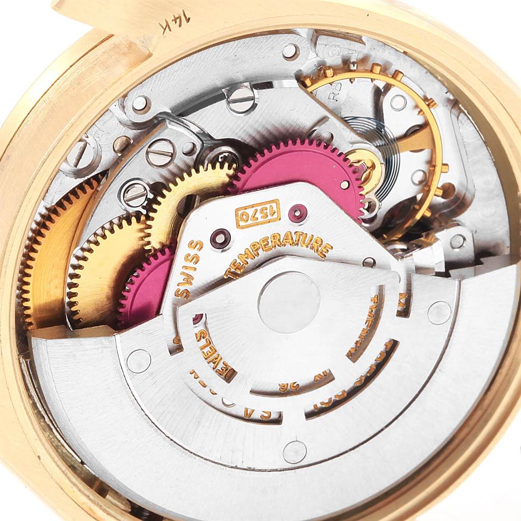 The image shows an angled close-up of the internal mechanics of a Rolex Vintage Collection 1007 Men's Yellow Gold Silver Dial 1007 Men's Yellow Gold Silver Dial watch, revealing gears and the movement assembly.