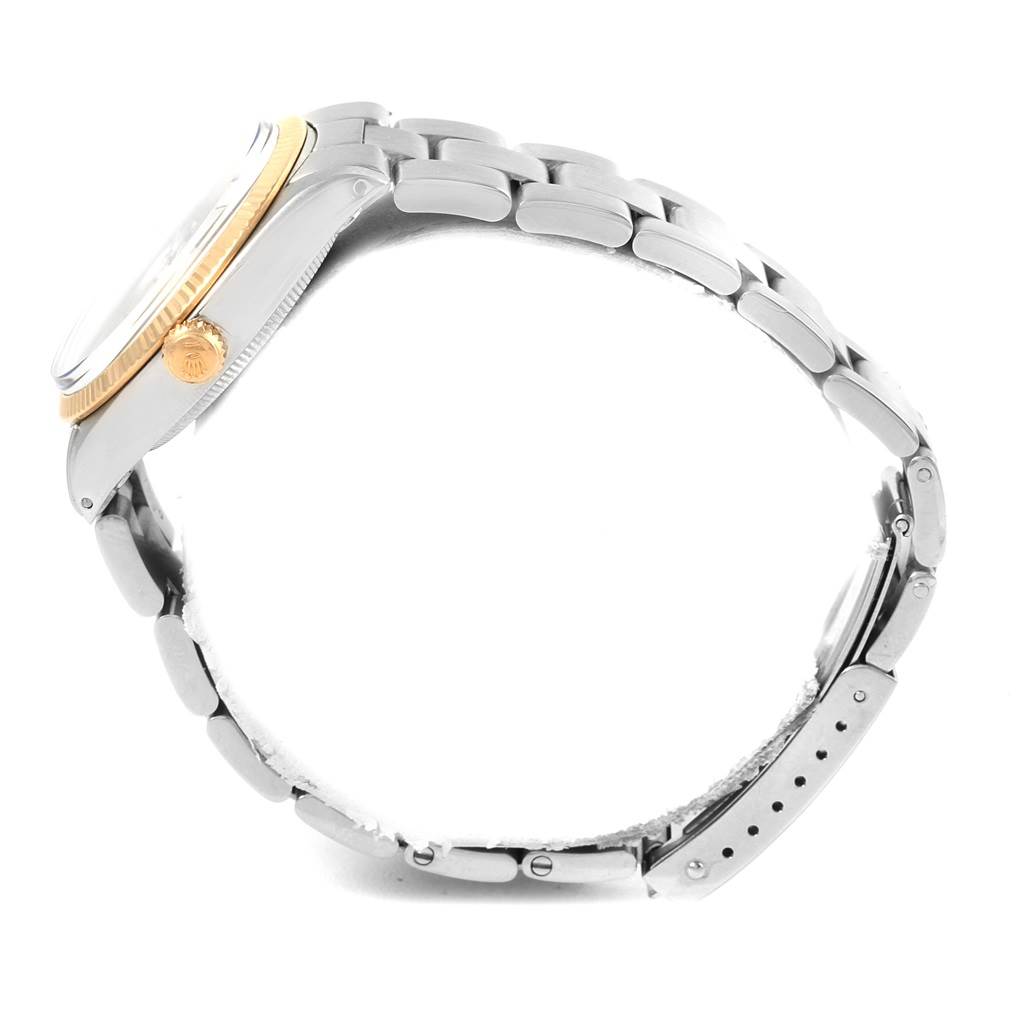 This side view of the Rolex Vintage Collection 5501 Men's Steel and Gold (two tone) Silver Dial 5501 Men's Steel and Gold (two tone) Silver Dial watch shows the crown, bezel, and bracelet.