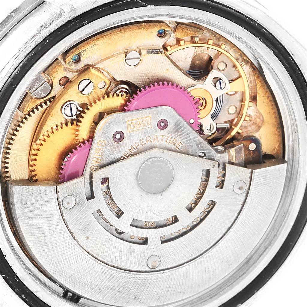 The image shows an internal view of a Rolex Vintage Collection 1675 Men's Stainless Steel Black Dial 1675 Men's Stainless Steel Black Dial watch, highlighting its intricate mechanical movement and gears.