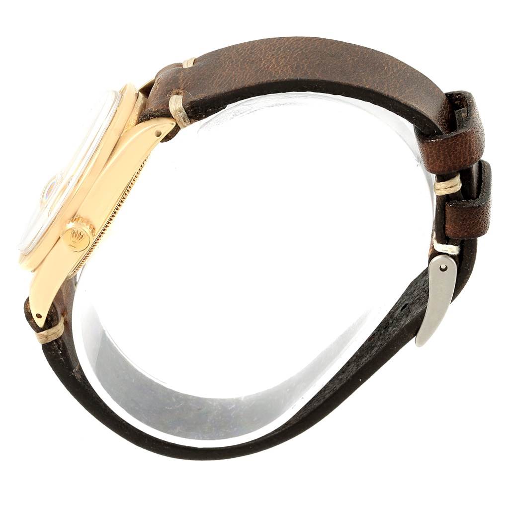 The image shows a side view of a Rolex Vintage Collection 1501 Men's Yellow Gold Champagne Dial 1501 Men's Yellow Gold Champagne Dial model watch, highlighting its crown and leather strap.