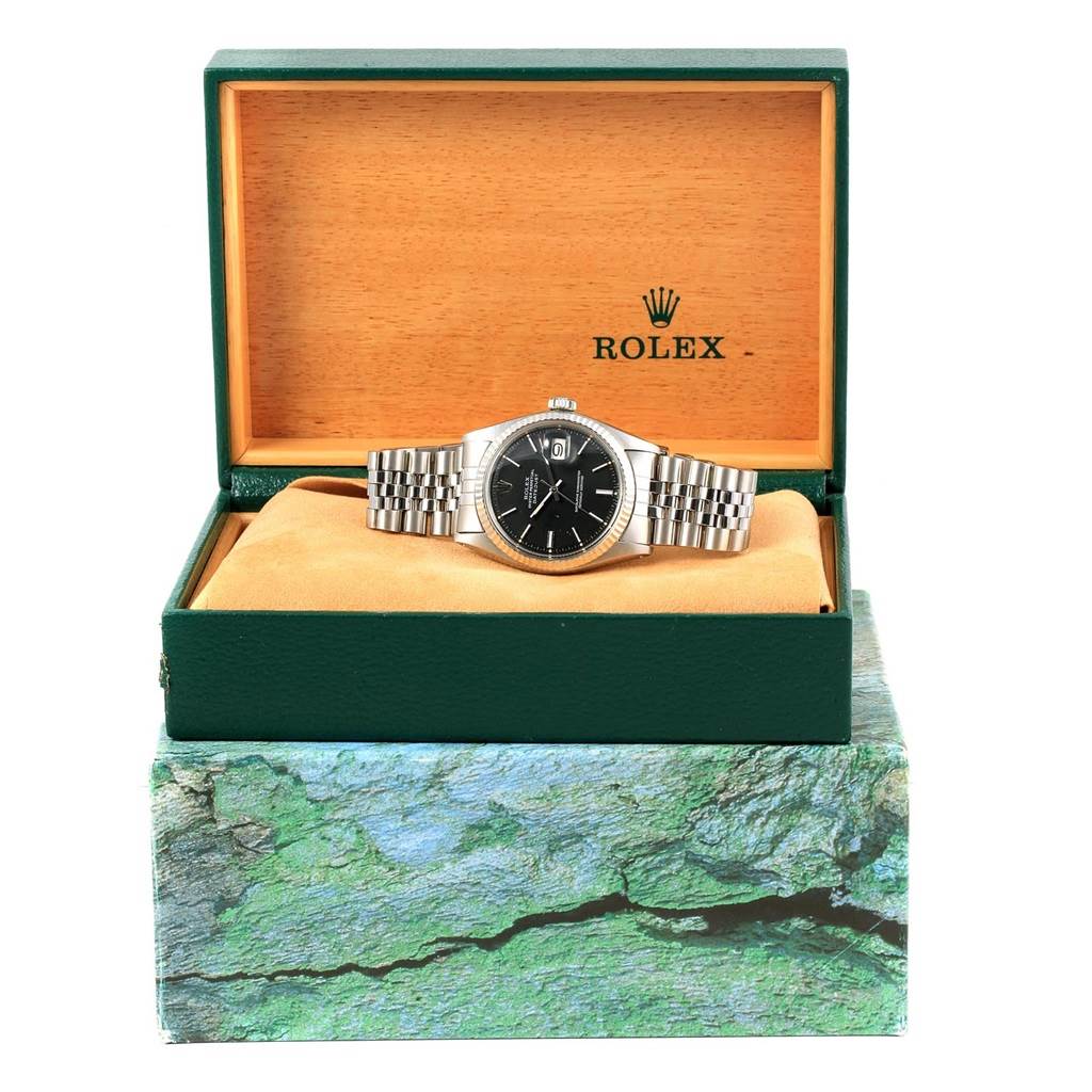 The Rolex Vintage Collection 1601 Men's Stainless Steel Black Dial 1601 Men's Stainless Steel Black Dial watch is shown front-on inside its green and wood-finished box, with its metal bracelet laid out.