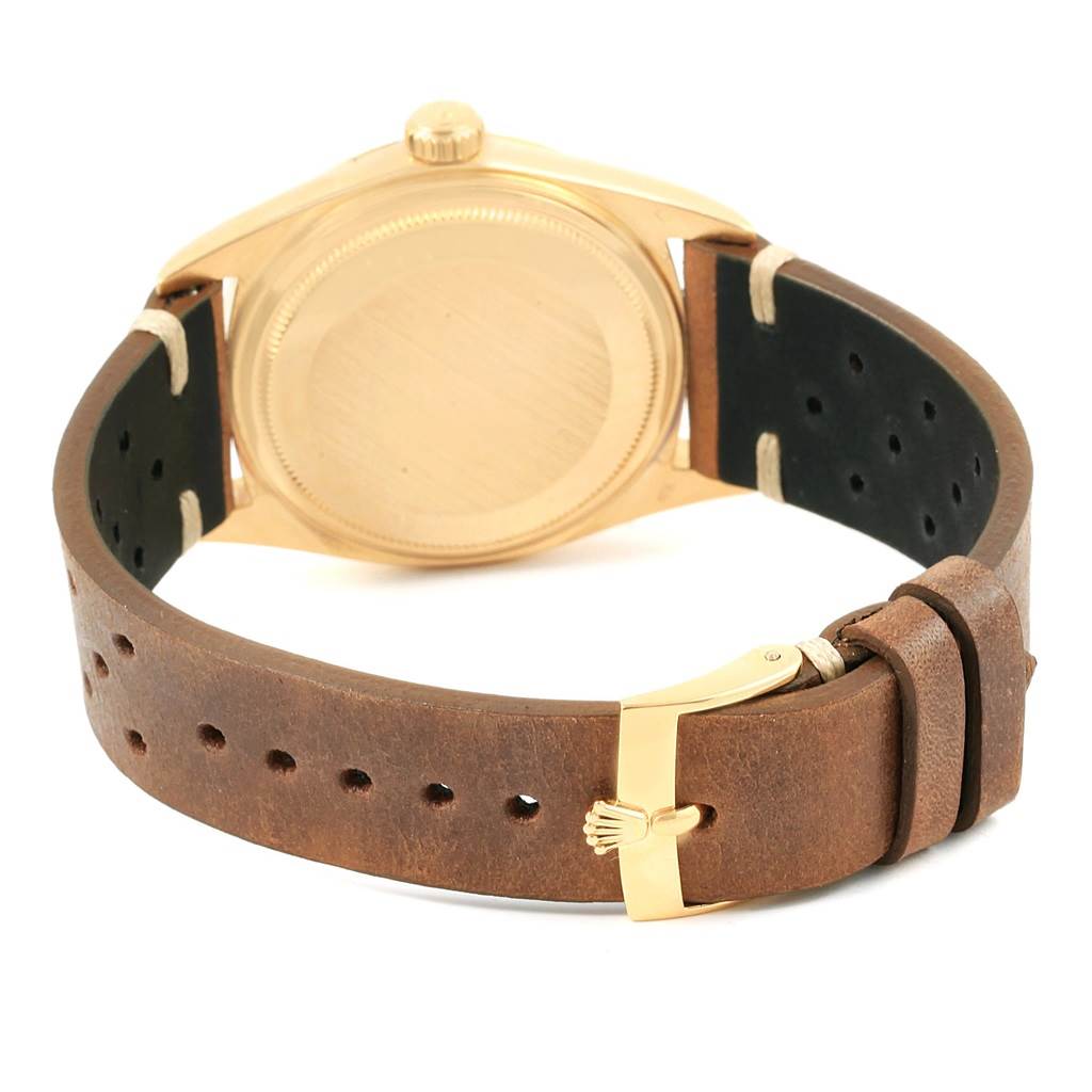 The image shows the back view of a Rolex Vintage Collection 1807 Men's Yellow Gold Champagne Dial 1807 Men's Yellow Gold Champagne Dial watch featuring a leather strap and gold buckle.