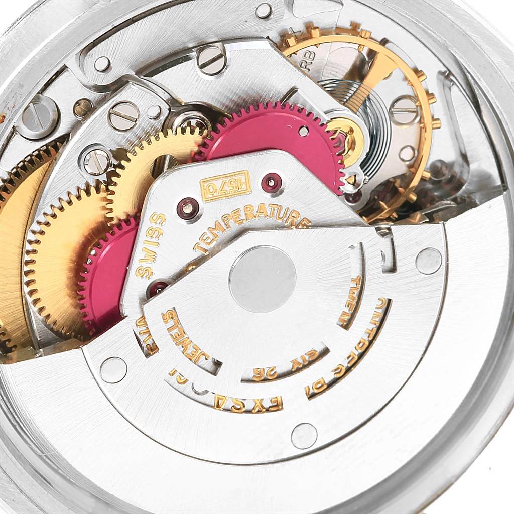 The image shows a close-up view of the mechanical movement inside a Vintage Collection Rolex watch, focusing on gears and intricate components.