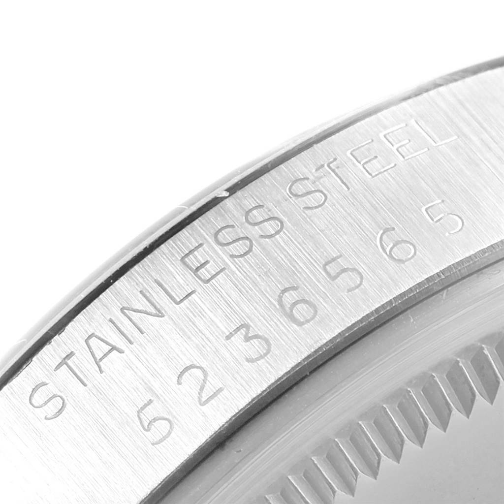 This image shows a close-up angle of the rim of the bezel displaying "STAINLESS STEEL" and a serial number on a Vintage Collection Rolex watch.