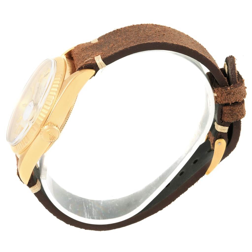 The Vintage Collection model by Rolex is shown from a side angle, highlighting its yellow gold case and brown leather strap.