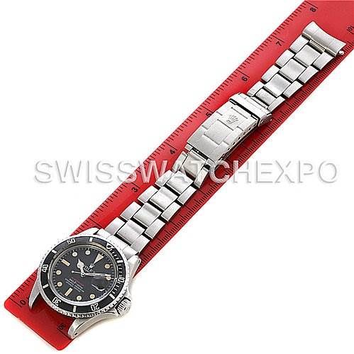 This image displays a Rolex Vintage Collection 1680 Men's Stainless Steel Black Dial 1680 Men's Stainless Steel Black Dial watch in a top-down view, showing the entire watch and its metal bracelet placed against a red ruler.
