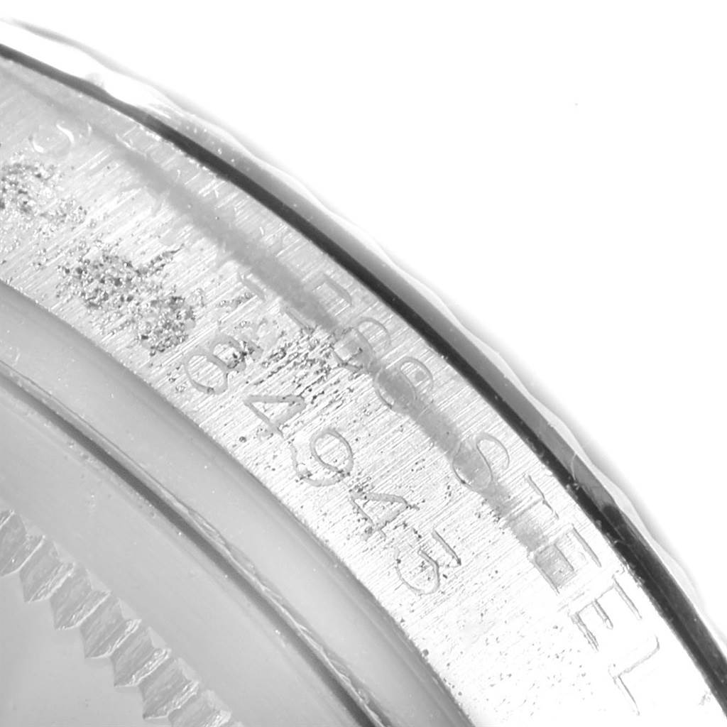 The image shows a close-up of the stainless steel edge and engraved serial number on a Vintage Collection model by Rolex.