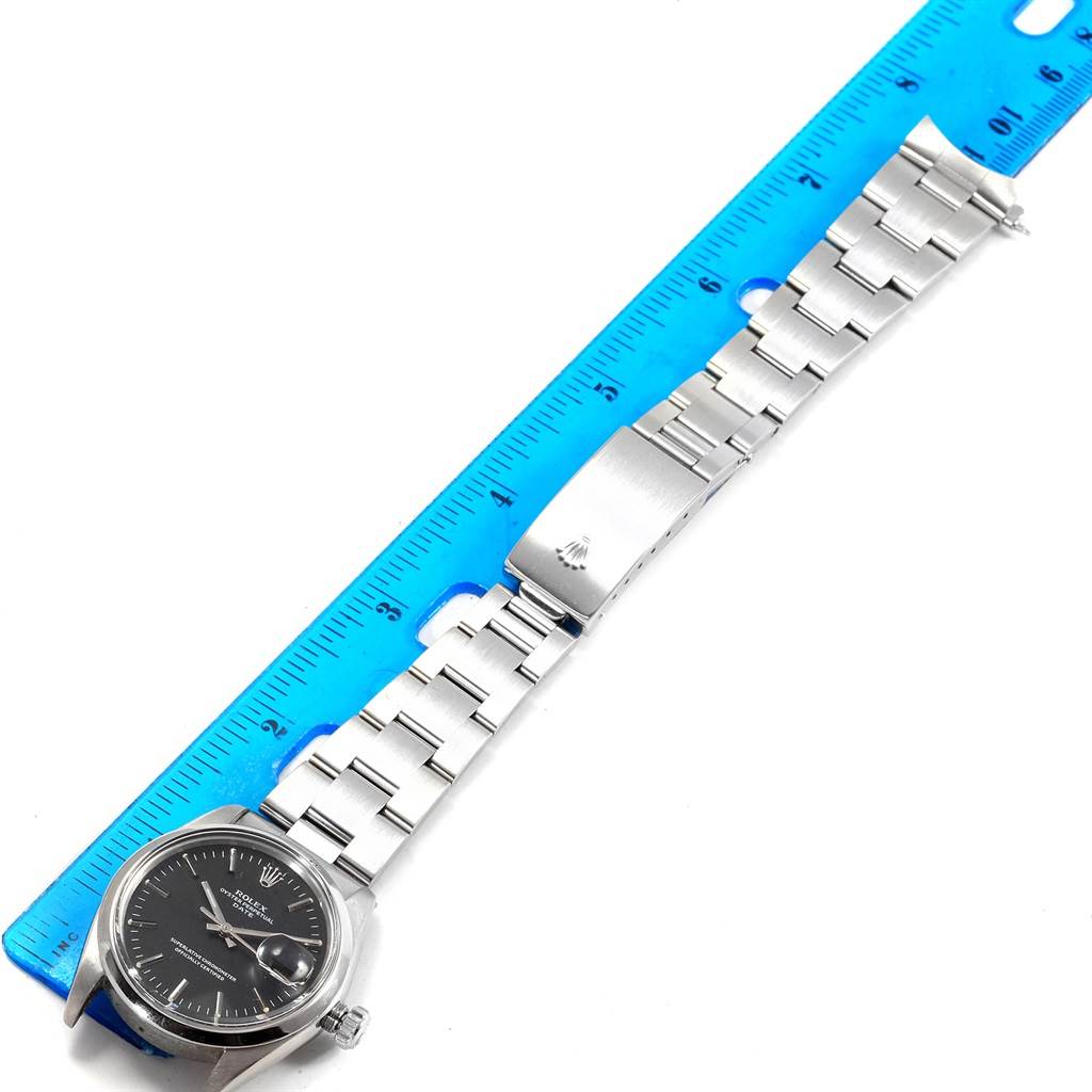 The image shows the whole Rolex Vintage Collection 1500 Men's Stainless Steel Black Dial 1500 Men's Stainless Steel Black Dial watch laid flat next to a blue ruler for measurement.