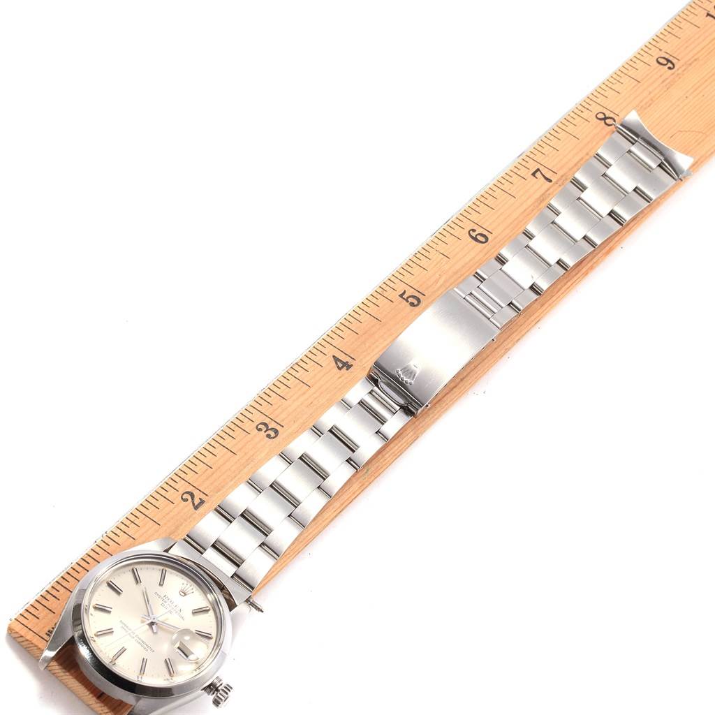 This image shows a Rolex Vintage Collection 1500 Men's Stainless Steel Silver Dial 1500 Men's Stainless Steel Silver Dial watch laid flat next to a wooden ruler, displaying its face and metal bracelet.