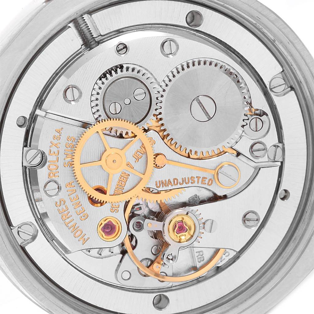 The image shows a close-up of the internal mechanism of a Vintage Collection Rolex watch, displaying gears and movement components.