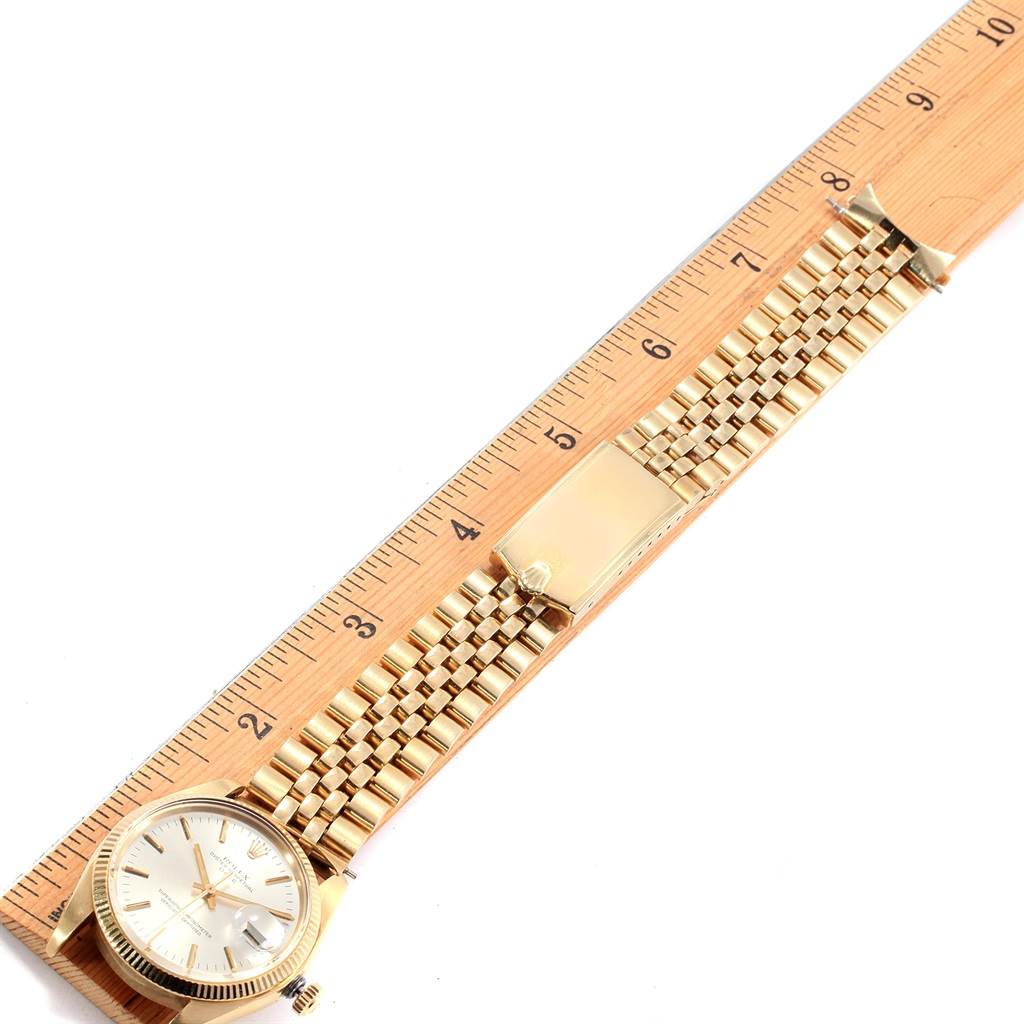 The Rolex Vintage Collection 1503 Men's Yellow Gold Silver Dial 1503 Men's Yellow Gold Silver Dial watch is shown from a top-down angle, displaying its face, bracelet, and clasp next to a ruler.