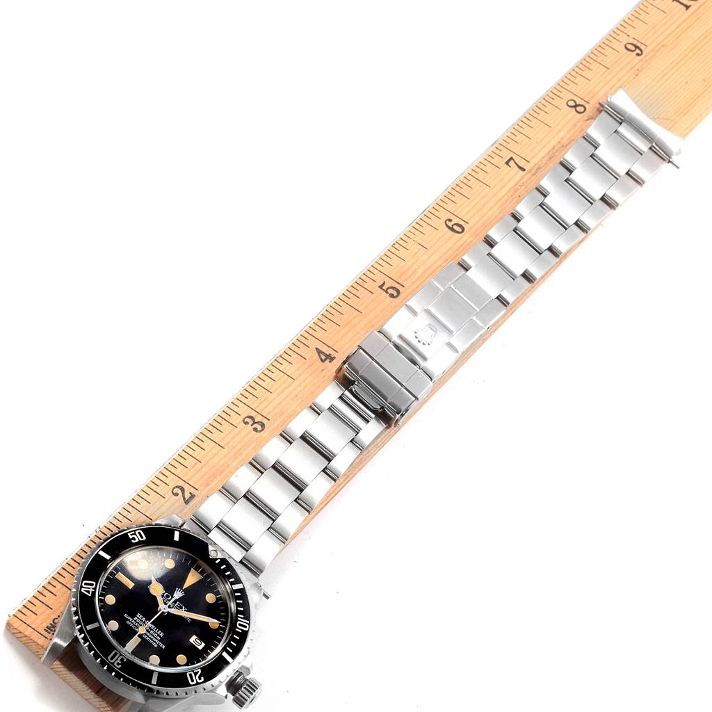 The Rolex Vintage Collection 1665 Men's Stainless Steel Black Dial 1665 Men's Stainless Steel Black Dial watch is shown from a top-down angle, displaying the watch face and metal bracelet next to a ruler.