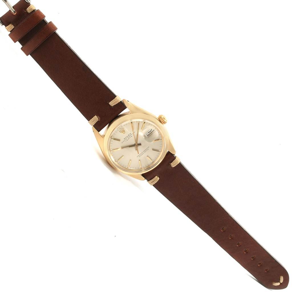 The Rolex Vintage Collection 1500 Men's Yellow Gold Silver Dial 1500 Men's Yellow Gold Silver Dial model watch is shown at an angled view displaying its face, crown, bezel, and leather strap.