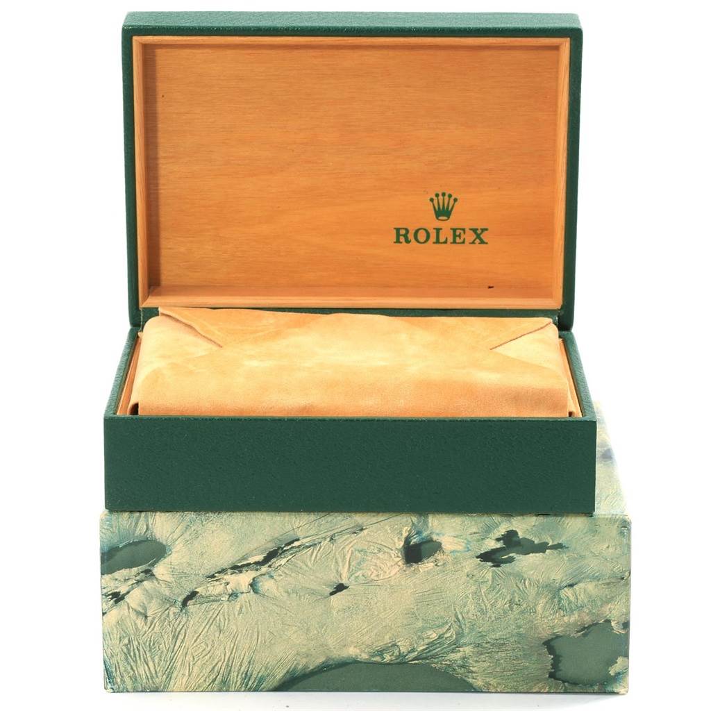 The image shows an open green and wooden Rolex box from the Vintage Collection model, with a suede pouch inside.