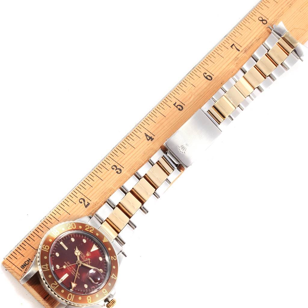 The image shows the face and band of a Rolex Vintage Collection 16753 Men's Stainless Steel Brown Dial 16753 Men's Stainless Steel Brown Dial watch, positioned beside a wooden ruler for scale.