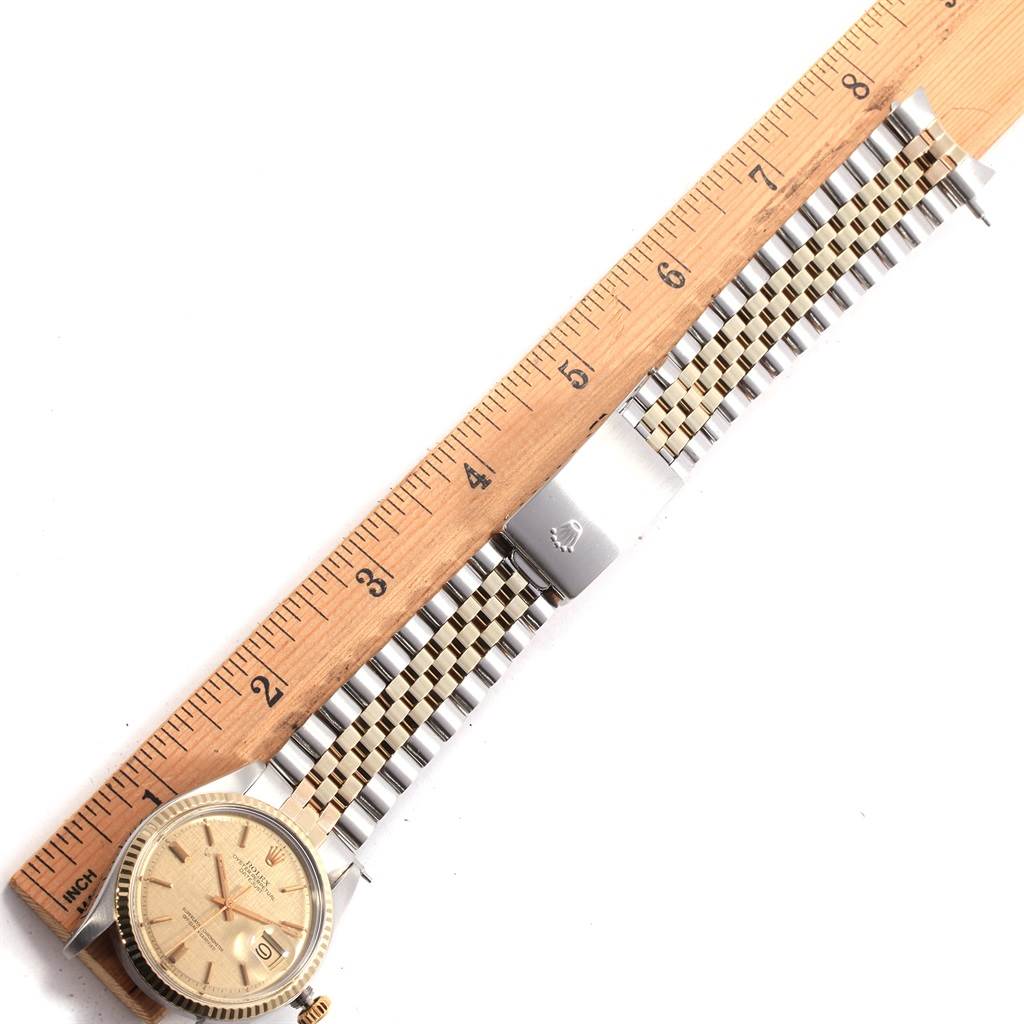 The image shows the Rolex Vintage Collection 1601 Men's Steel and Gold (two tone) Champagne Dial 1601 Men's Steel and Gold (two tone) Champagne Dial model watch laid next to a ruler, displaying its face and bracelet.