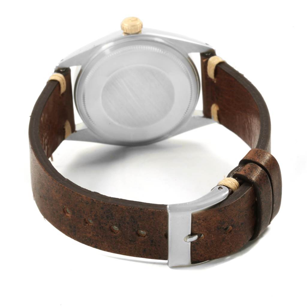 The image shows the back view of a Rolex Vintage Collection 1601 Men's Steel and Gold (two tone) Grey Dial 1601 Men's Steel and Gold (two tone) Grey Dial watch, highlighting its case back and leather strap.