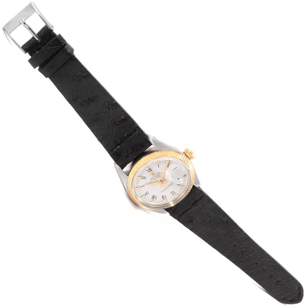 The Vintage Collection watch by Rolex is shown fully extended from a top-down angle, highlighting its black strap, white face, and gold bezel.