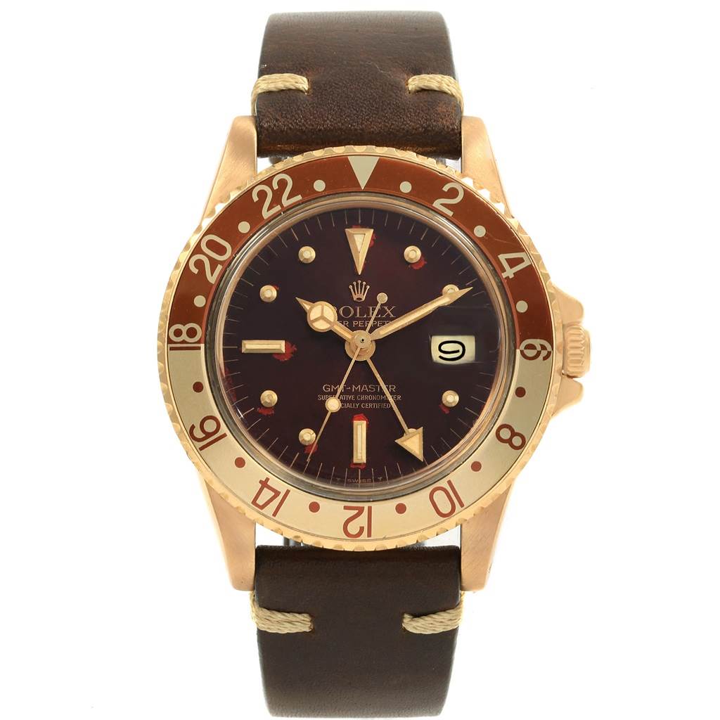 The image shows a front view of a Rolex Vintage Collection 1675 Men's Yellow Gold Brown Dial 1675 Men's Yellow Gold Brown Dial watch, featuring a brown bezel, a leather strap, and a date display.