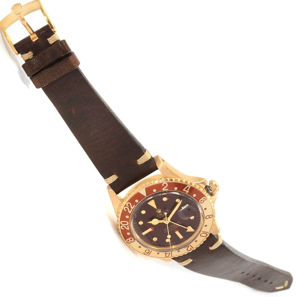 The image shows a Rolex Vintage Collection 1675 Men's Yellow Gold Brown Dial 1675 Men's Yellow Gold Brown Dial watch from an overhead angle, highlighting its strap, dial, bezel, and crown.