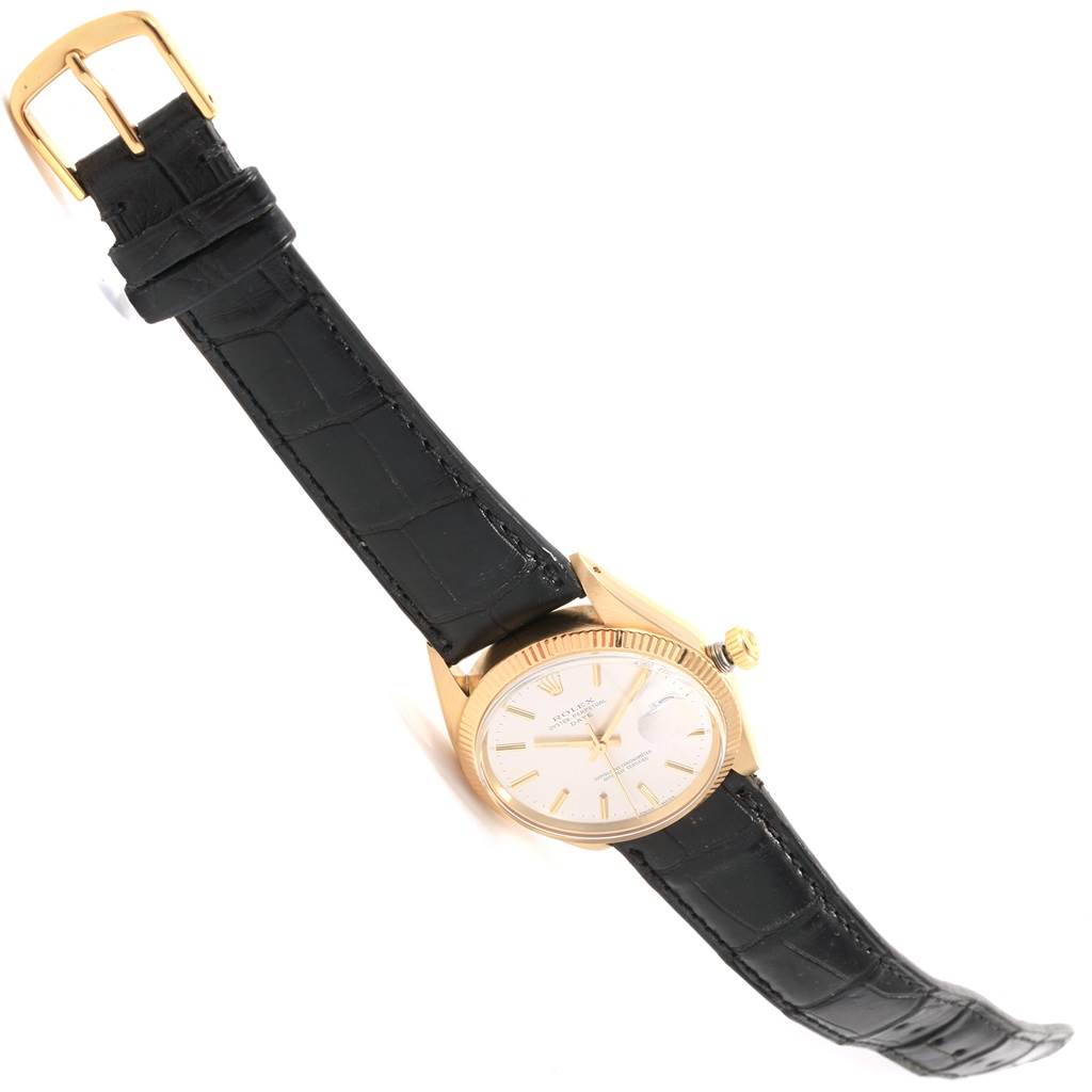 The Vintage Collection Rolex watch is shown from a tilted top-down view, highlighting the dial, bezel, crown, and black leather strap.