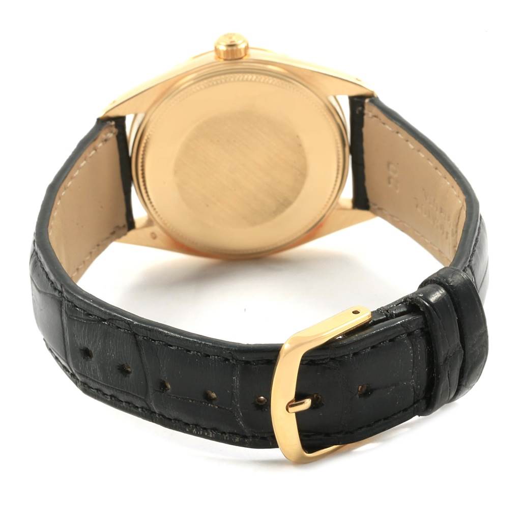 This image shows the back view of a Vintage Collection Rolex watch, highlighting its black leather strap and gold buckle.