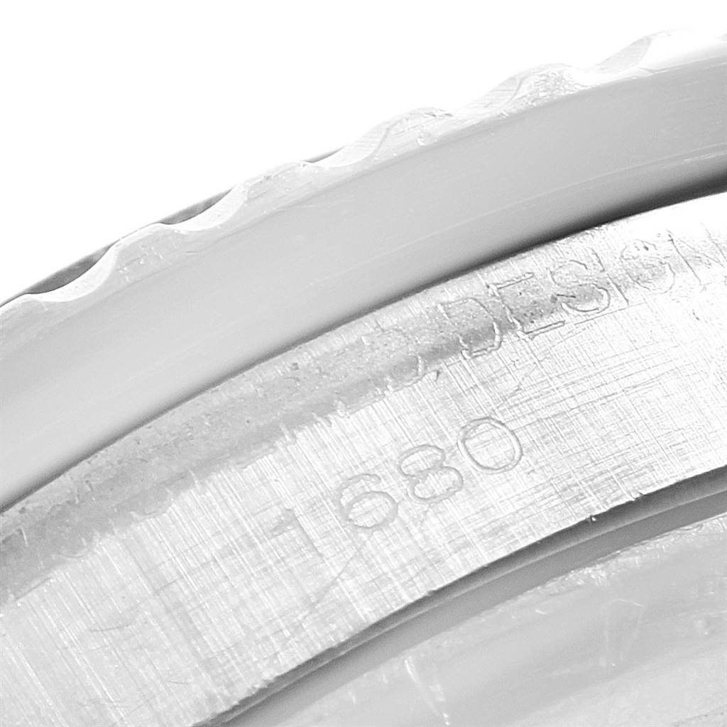 The image shows a close-up of the bezel and a portion of the engraved serial number of the Rolex Vintage Collection 1680 Men's Stainless Steel Black Dial 1680 Men's Stainless Steel Black Dial model.