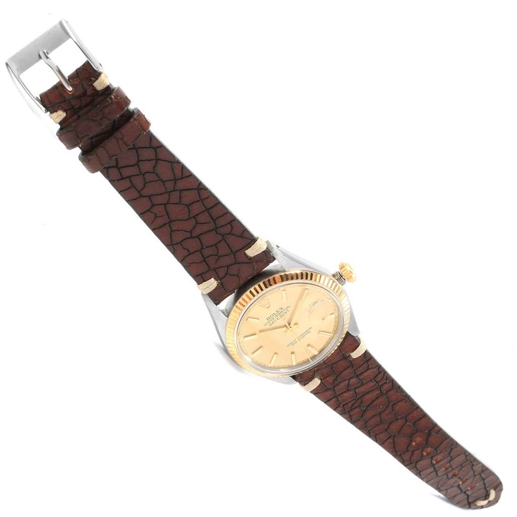 The Rolex Vintage Collection 1601 Men's Steel and Gold (two tone) Champagne Dial 1601 Men's Steel and Gold (two tone) Champagne Dial watch is shown at an angle highlighting the face, bezel, crown, and textured leather strap.