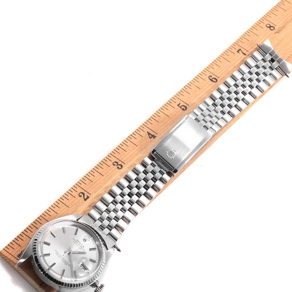 This image shows a Rolex Vintage Collection 1603 Men's Stainless Steel Silver Dial 1603 Men's Stainless Steel Silver Dial watch laid flat next to a ruler, displaying its face, bracelet, and clasp.