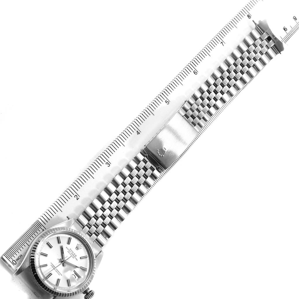 The image shows a Rolex Vintage Collection 1601 Men's Stainless Steel Silver Dial 1601 Men's Stainless Steel Silver Dial watch at a top-down angle, including the face, bracelet, and deployment clasp alongside a ruler.