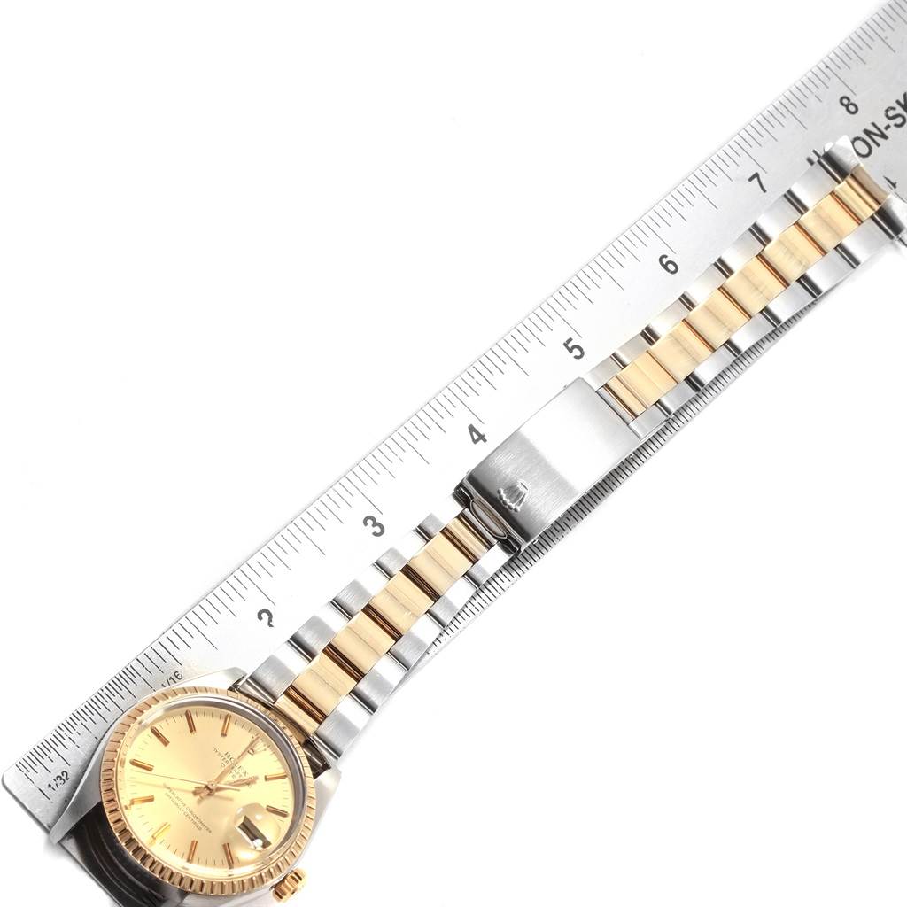 The image shows a top view of a Rolex Vintage Collection 1505 Men's Steel and Gold (two tone) Champagne Dial 1505 Men's Steel and Gold (two tone) Champagne Dial watch with its band placed alongside a ruler.