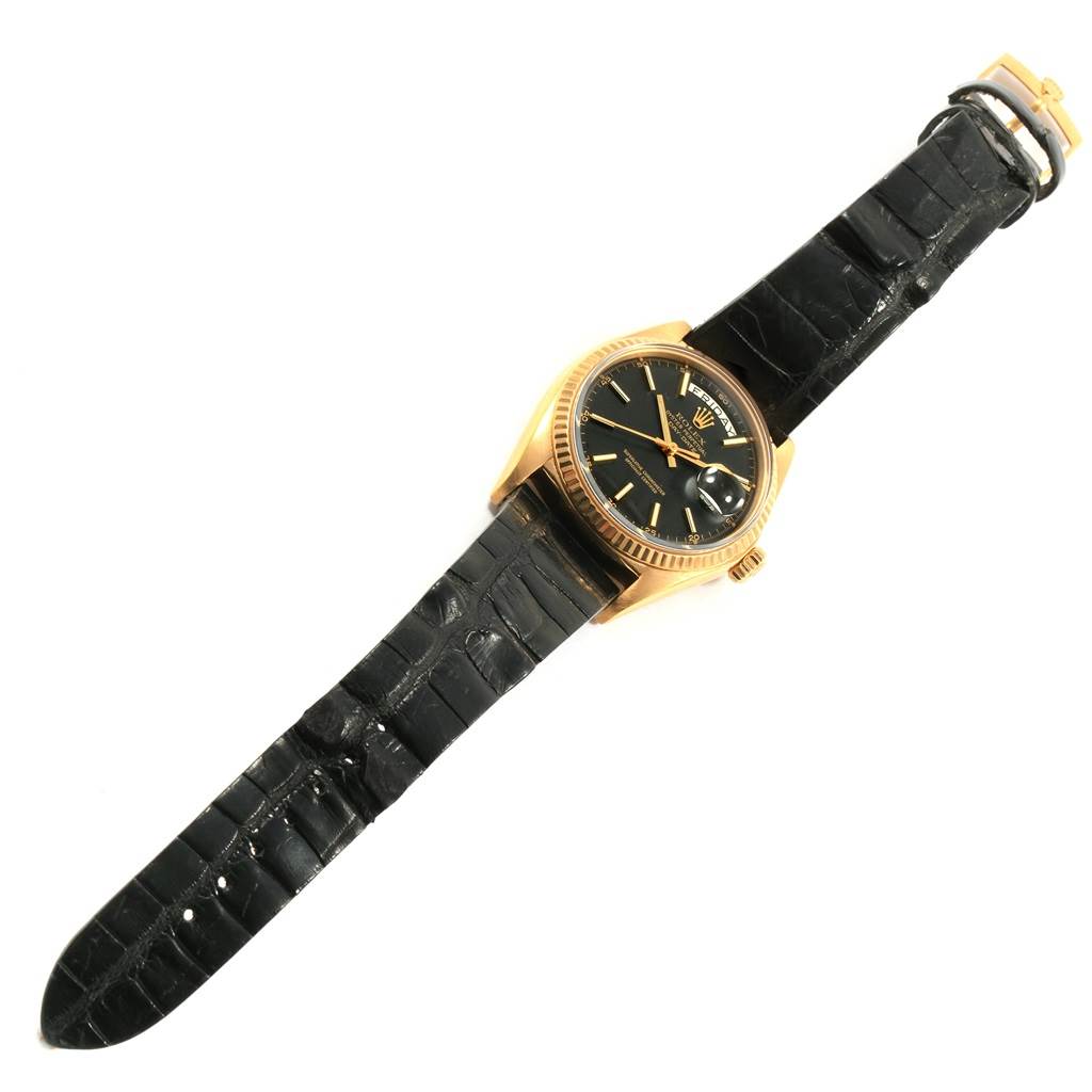 The image shows a Vintage Collection Rolex watch from an overhead angle featuring its black leather strap, gold case, and black dial.