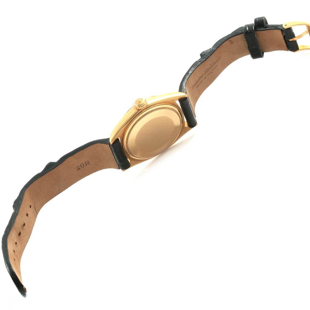 The image shows a Vintage Collection Rolex watch viewed from the back, displaying its gold case and leather strap.