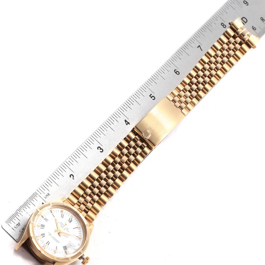 The image shows a Rolex Vintage Collection 15017 Men's Yellow Gold White Dial 15017 Men's Yellow Gold White Dial watch placed flat alongside a ruler, highlighting the watch face and metal strap.