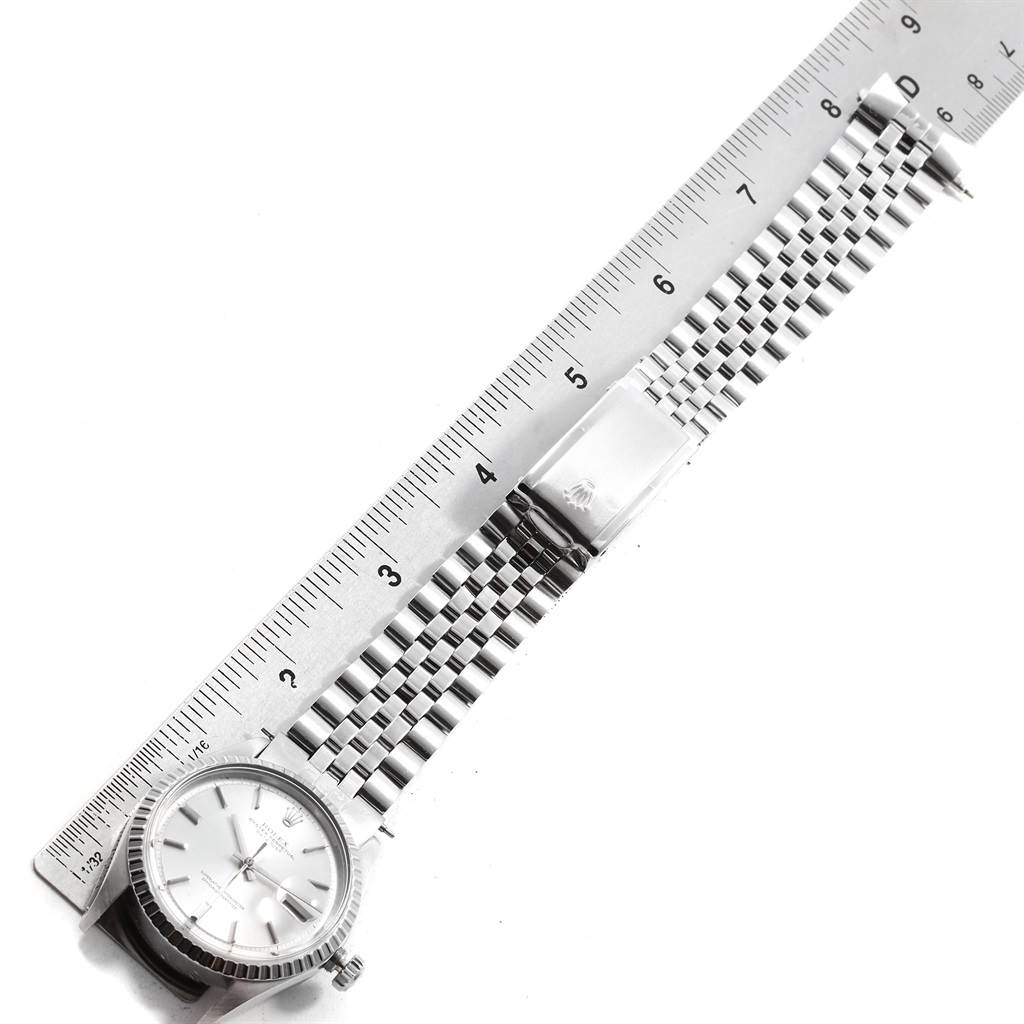 The image shows the face and metal band of the Rolex Vintage Collection 1603 Men
s Stainless Steel Silver Dial 1603 Men
s Stainless Steel Silver Dial watch, aligned next to a ruler.