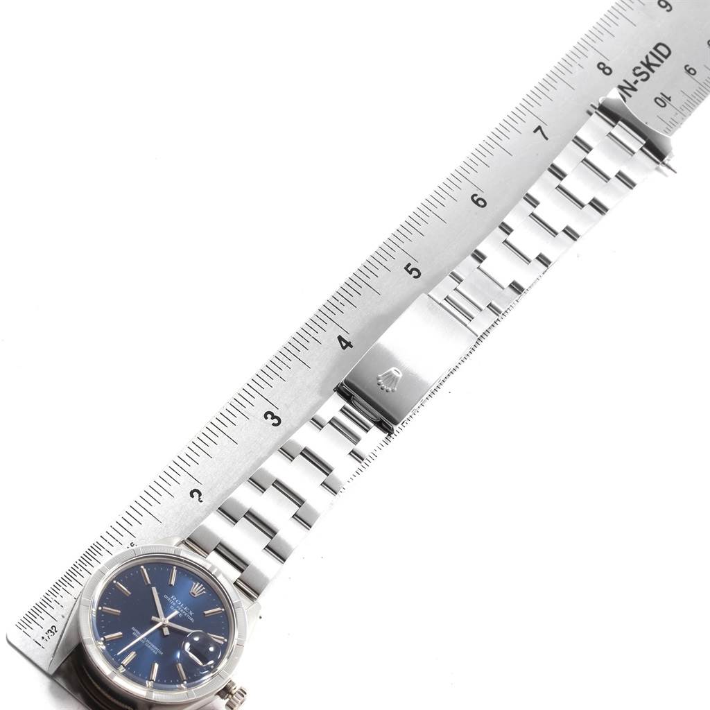 The image shows a Rolex Vintage Collection 1501 Men
s Stainless Steel Blue Dial 1501 Men
s Stainless Steel Blue Dial watch lying flat, with its face and metal strap measured against a ruler.