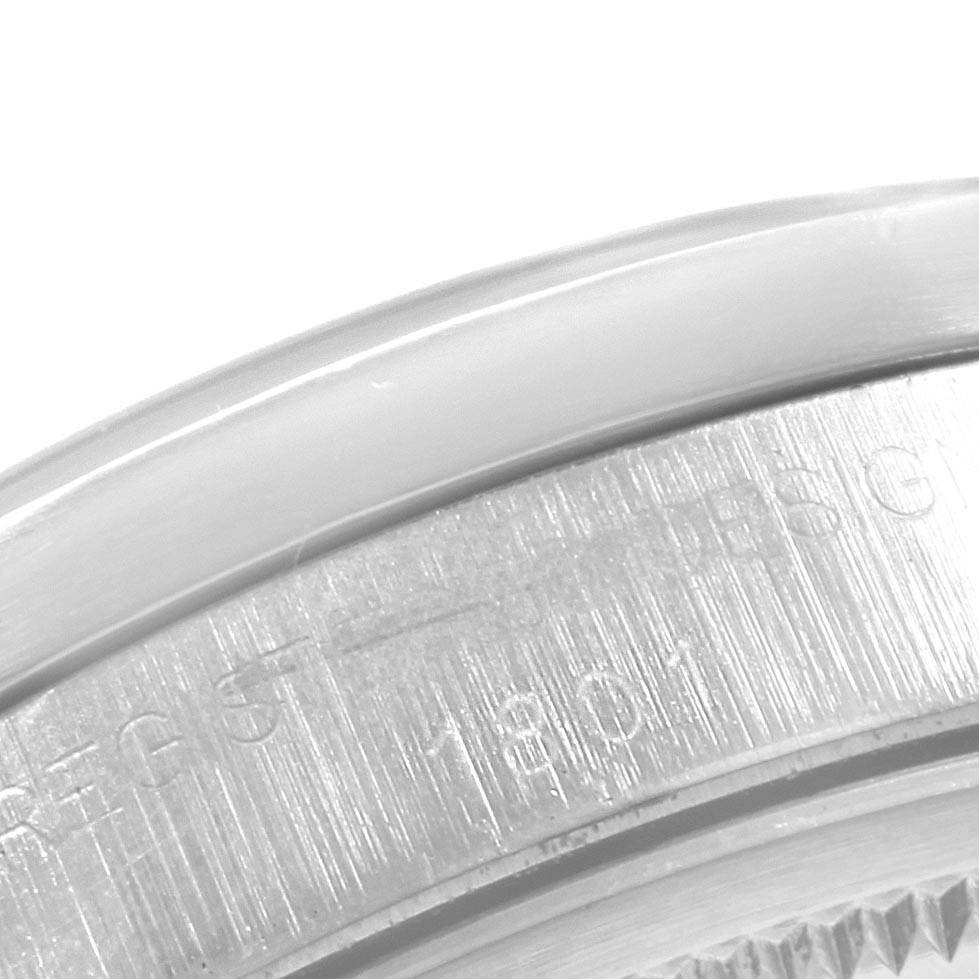 The image shows a close-up of the side and back of a Rolex Vintage Collection 1501 Men
s Stainless Steel Blue Dial 1501 Men
s Stainless Steel Blue Dial watch, focusing on the engraved details.