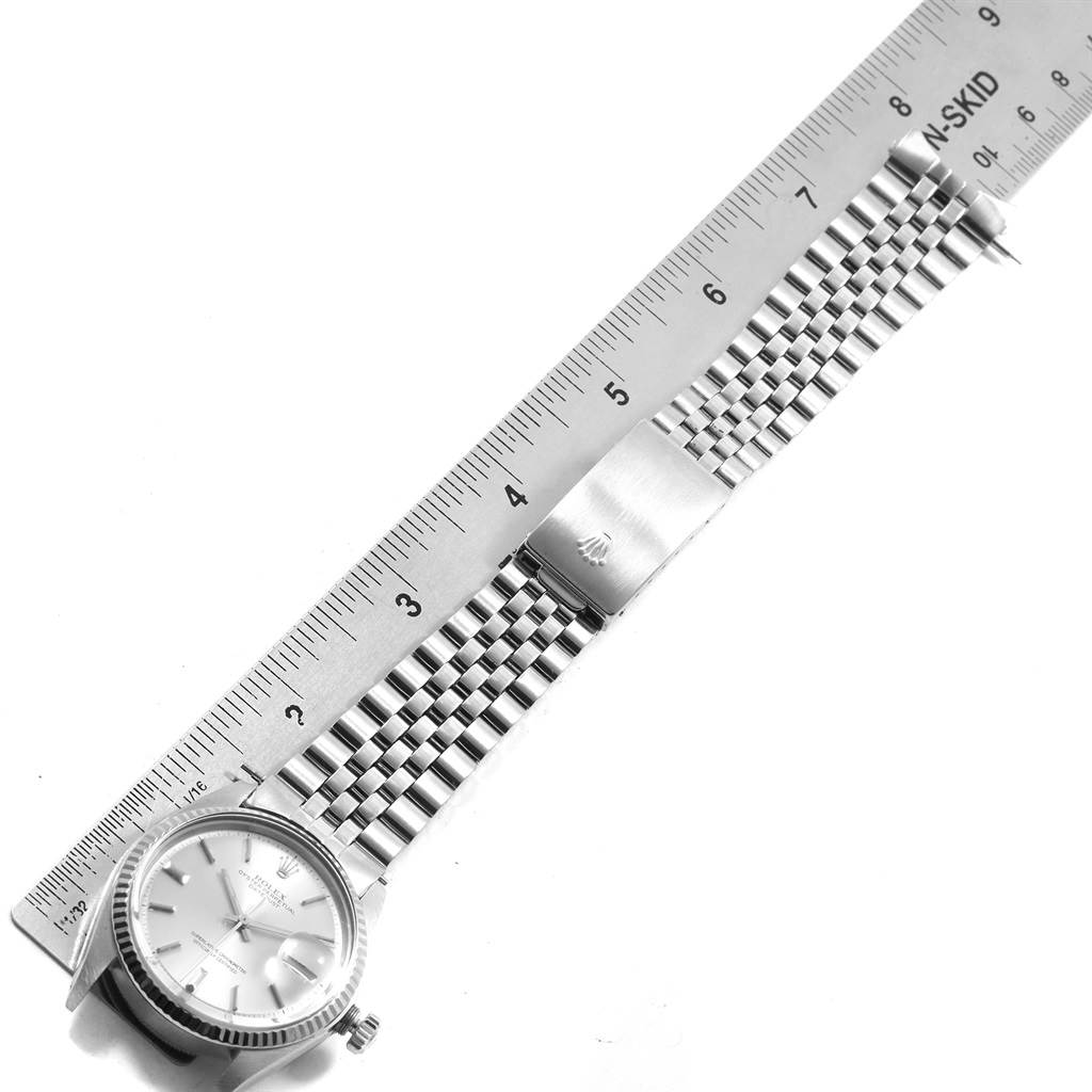 This image shows the Rolex Vintage Collection 1601 Men's Stainless Steel Silver Dial 1601 Men's Stainless Steel Silver Dial watch face and partially extended metal strap, aligned with a 12-inch ruler.