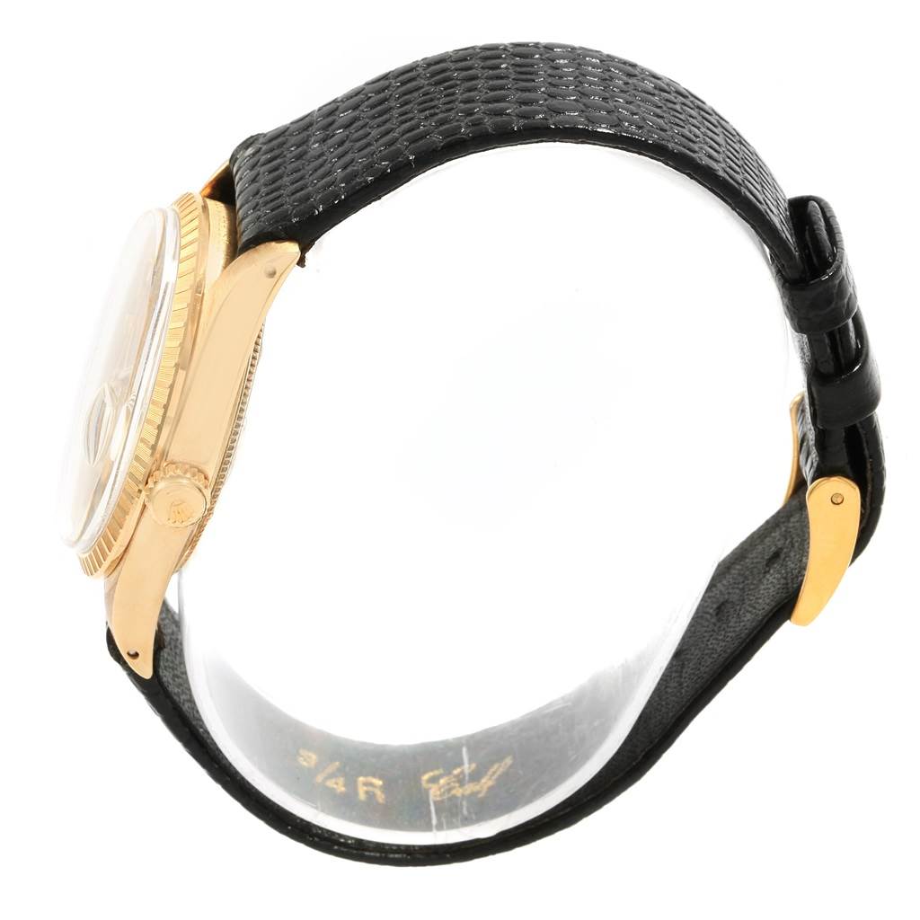 The Rolex Vintage Collection 1503 Men
s Yellow Gold Champagne Dial 1503 Men
s Yellow Gold Champagne Dial watch is shown from a side angle, displaying the gold case and crown along with a black textured band.