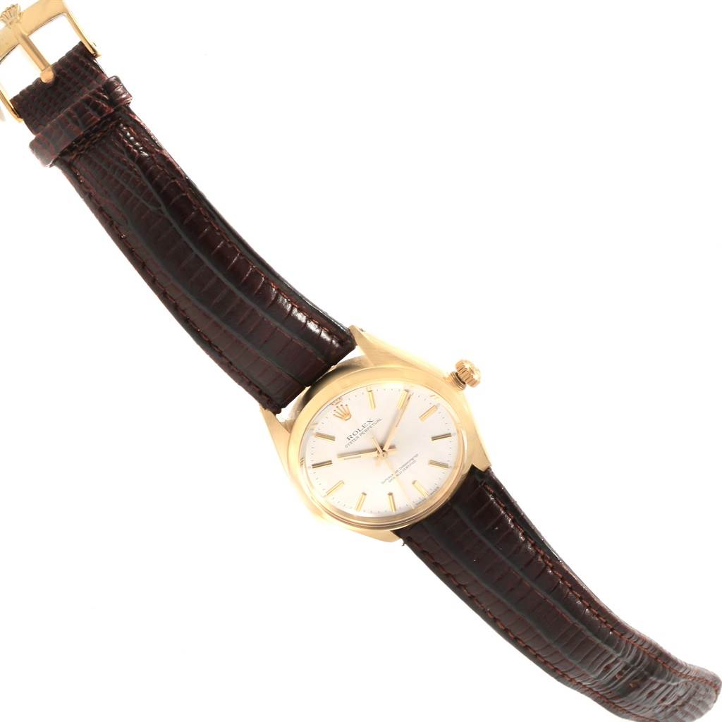 This image shows a close-up, angled view of a Rolex Vintage Collection 1002 Men's Yellow Gold Silver Dial 1002 Men's Yellow Gold Silver Dial model watch with a brown leather strap and gold case.