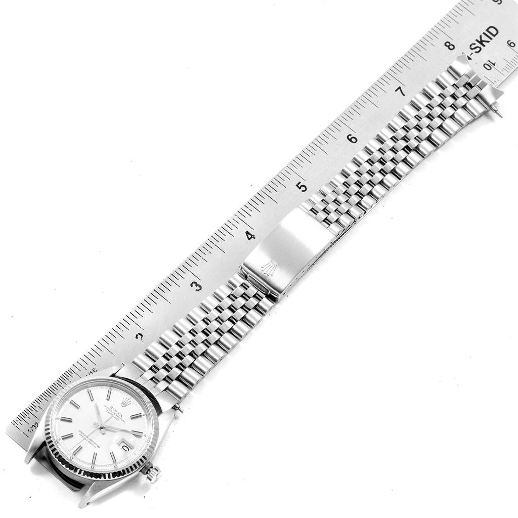 The image shows a top-down view of the Rolex Vintage Collection 1601 Men's Stainless Steel Silver Dial 1601 Men's Stainless Steel Silver Dial model watch, including the dial, case, and metal bracelet with a clasp near a ruler.