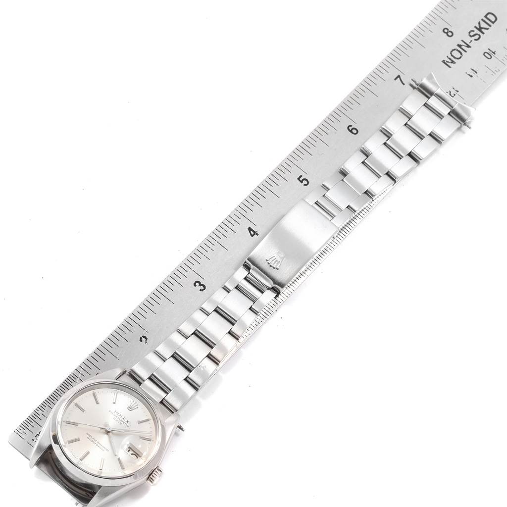 The image shows the Rolex Vintage Collection 1500 Men
s Stainless Steel Silver Dial 1500 Men
s Stainless Steel Silver Dial watch at a top-down angle alongside a ruler, highlighting the band and clasp.
