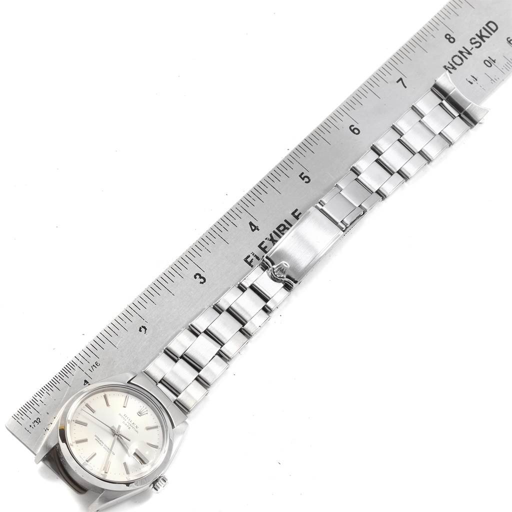 The Rolex Vintage Collection 1500 Men
s Stainless Steel Silver Dial 1500 Men
s Stainless Steel Silver Dial watch is shown from a top-down angle, displaying its face, bracelet, and clasp alongside a ruler for scale.