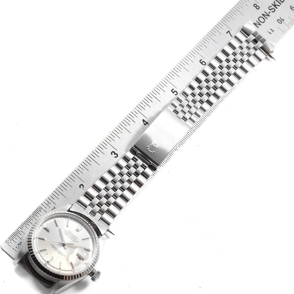 The Rolex Vintage Collection 1601 Men
s Stainless Steel Silver Dial 1601 Men
s Stainless Steel Silver Dial watch is shown from a top-down angle, displaying its face and metal bracelet against a ruler.